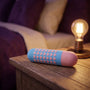 Sfeerbeeld: Mini vibrator Heart op een houten nachtkastje bij een brandende lamp