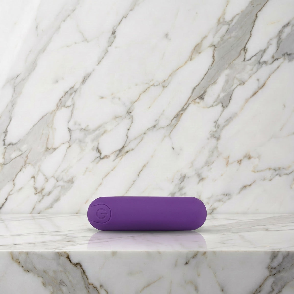 Paarse oplaadbare bullet vibrator liggend op een marmeren plank