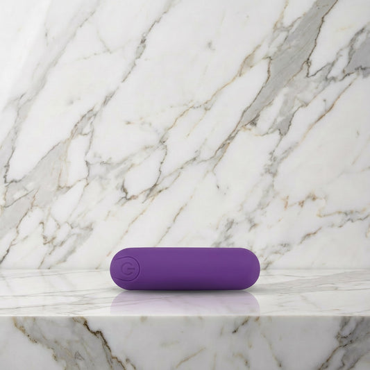 Paarse oplaadbare bullet vibrator liggend op een marmeren plank