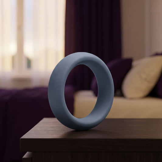 Sfeerbeeld: leigrijze cockring van 40 mm op een houten nachtkastje in een slaapkamer