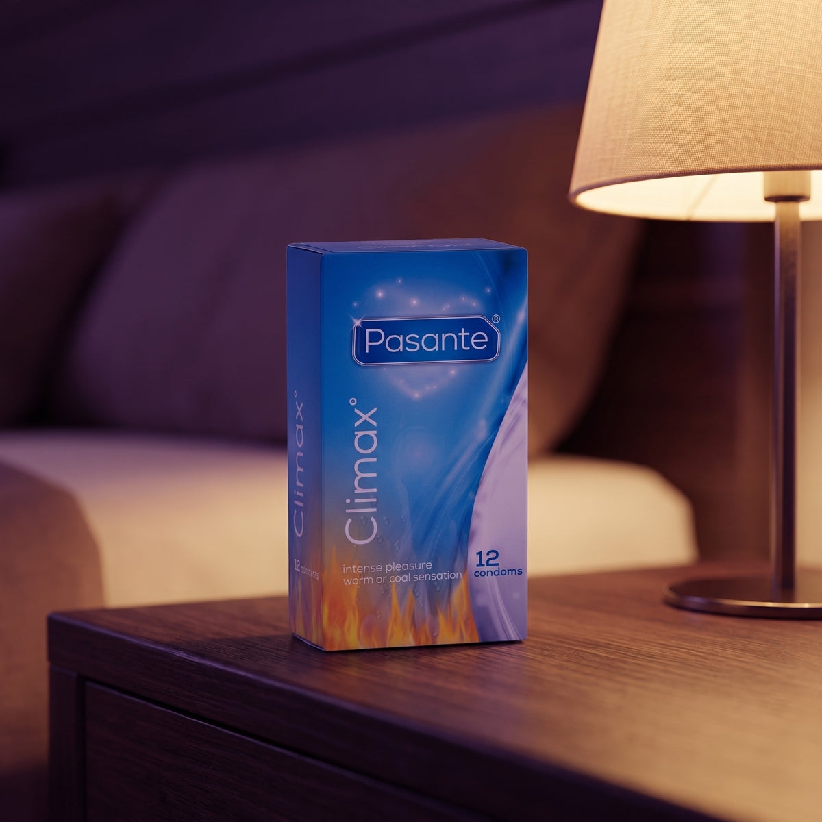 Sfeerbeeld: doosje Pasante Climax condooms op een nachtkastje bij een brandende lamp