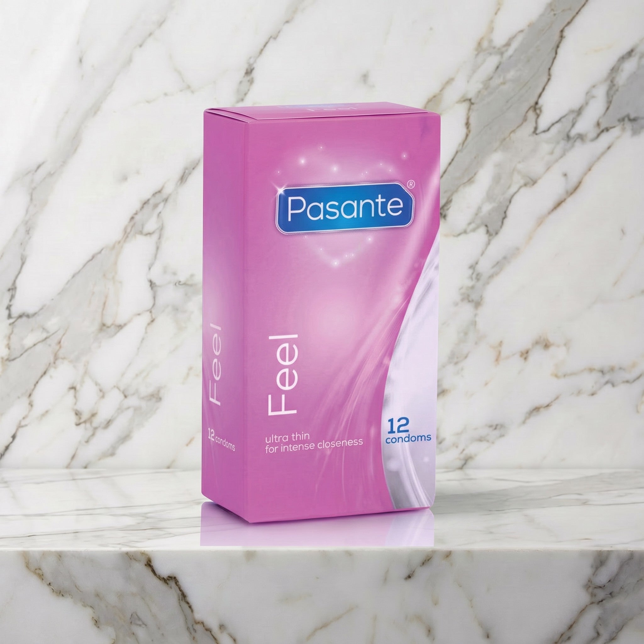 Roze doosje Pasante Feel ultradunne condooms rechtop op een marmeren plank