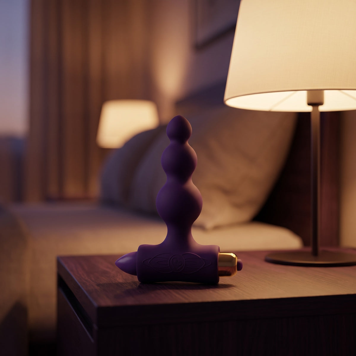 Sfeerbeeld: de Petite Sensations Bubble op een houten nachtkastje naast een brandende lamp
