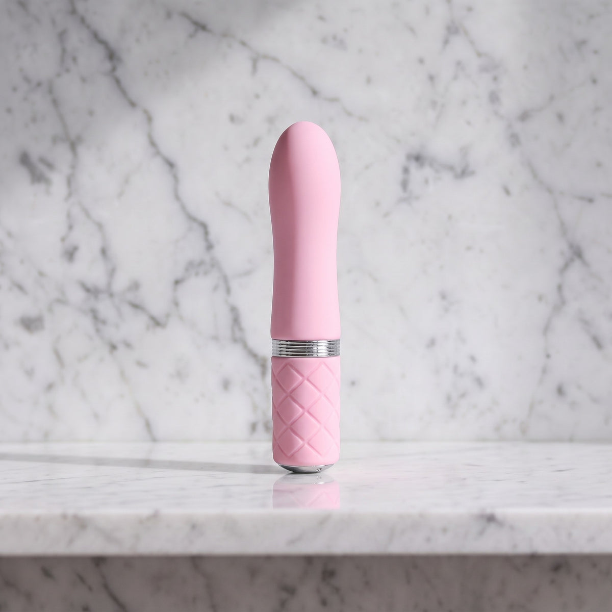Licht roze mini vibrator met ruitjesgreep rechtop op een marmeren plank, Pillow Talk Flirty