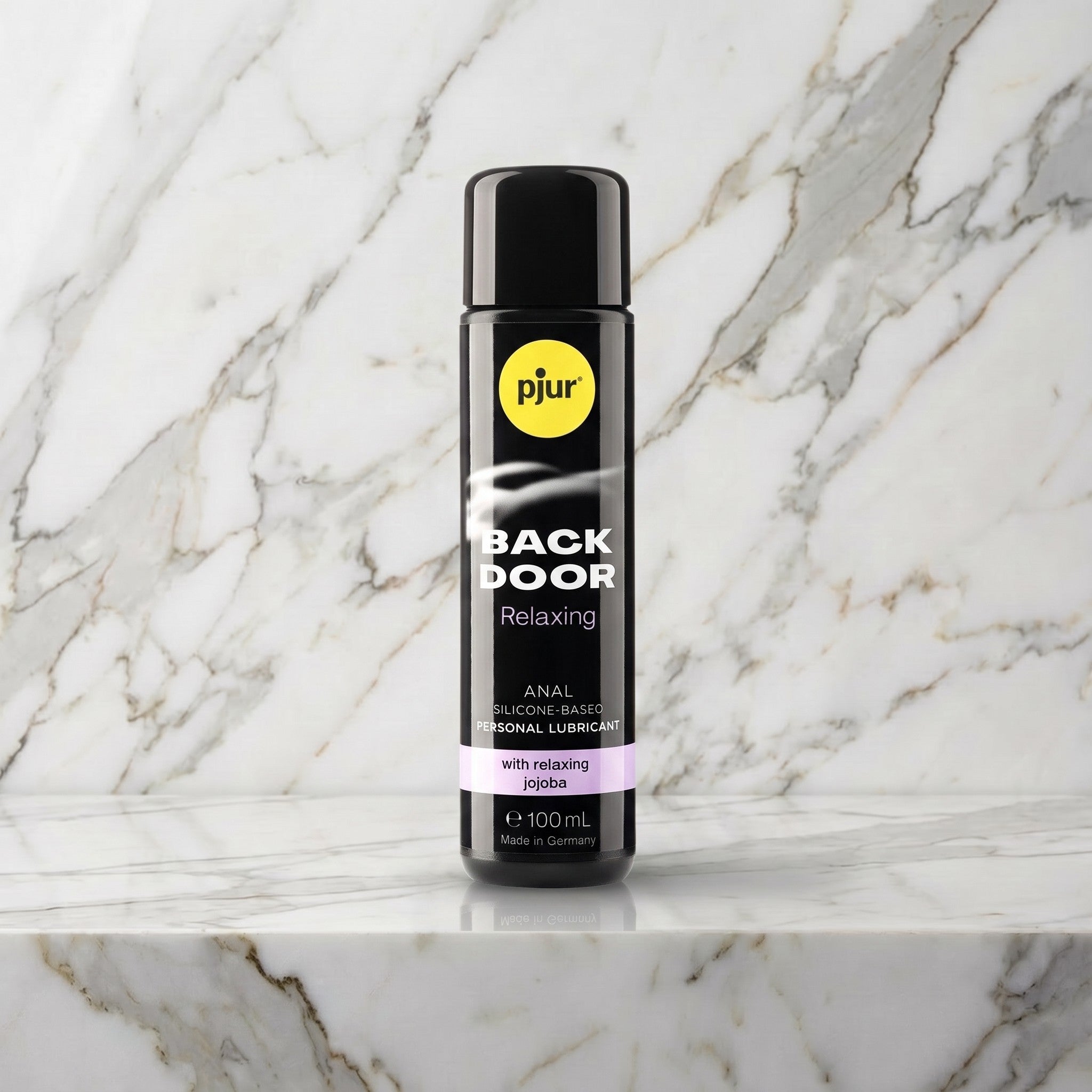 Zwarte fles Pjur Back Door Relaxing anaal glijmiddel van 100 ml op een marmeren plank