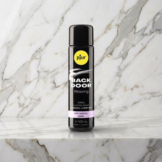 Zwarte fles Pjur Back Door Relaxing anaal glijmiddel van 100 ml op een marmeren plank