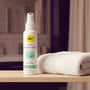 Sfeerbeeld: witte fles pjur med After Shave op een badkamerplank naast een witte handdoek