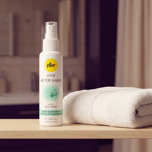 Sfeerbeeld: witte fles pjur med After Shave op een badkamerplank naast een witte handdoek