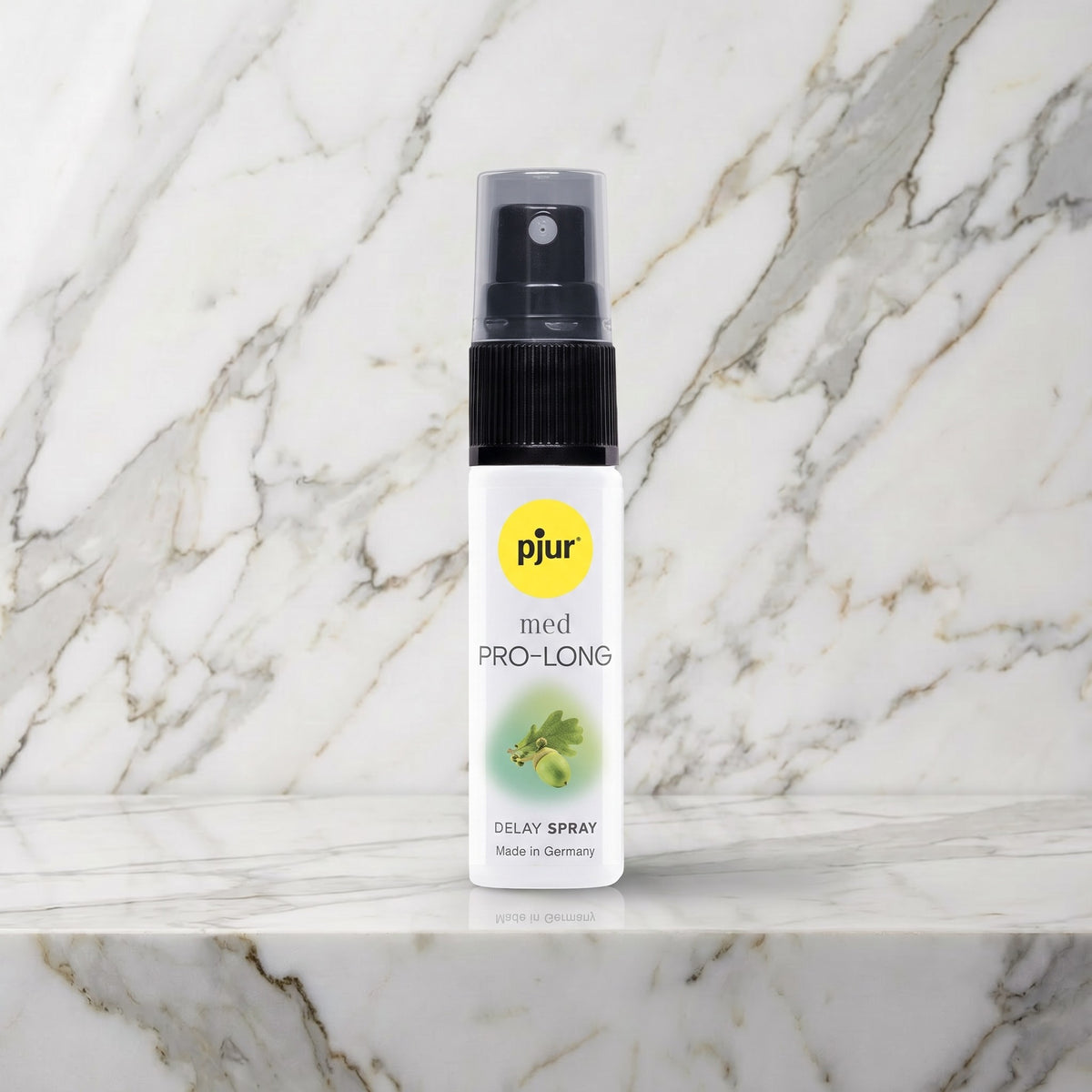 Witte sprayflacon pjur med Pro-Long met zwarte spraykop op een marmeren plank