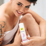 Vrouw toont Pjur Woman siliconenbasis glijmiddel 100 ml, witte fles met roze design, sfeerbeeld