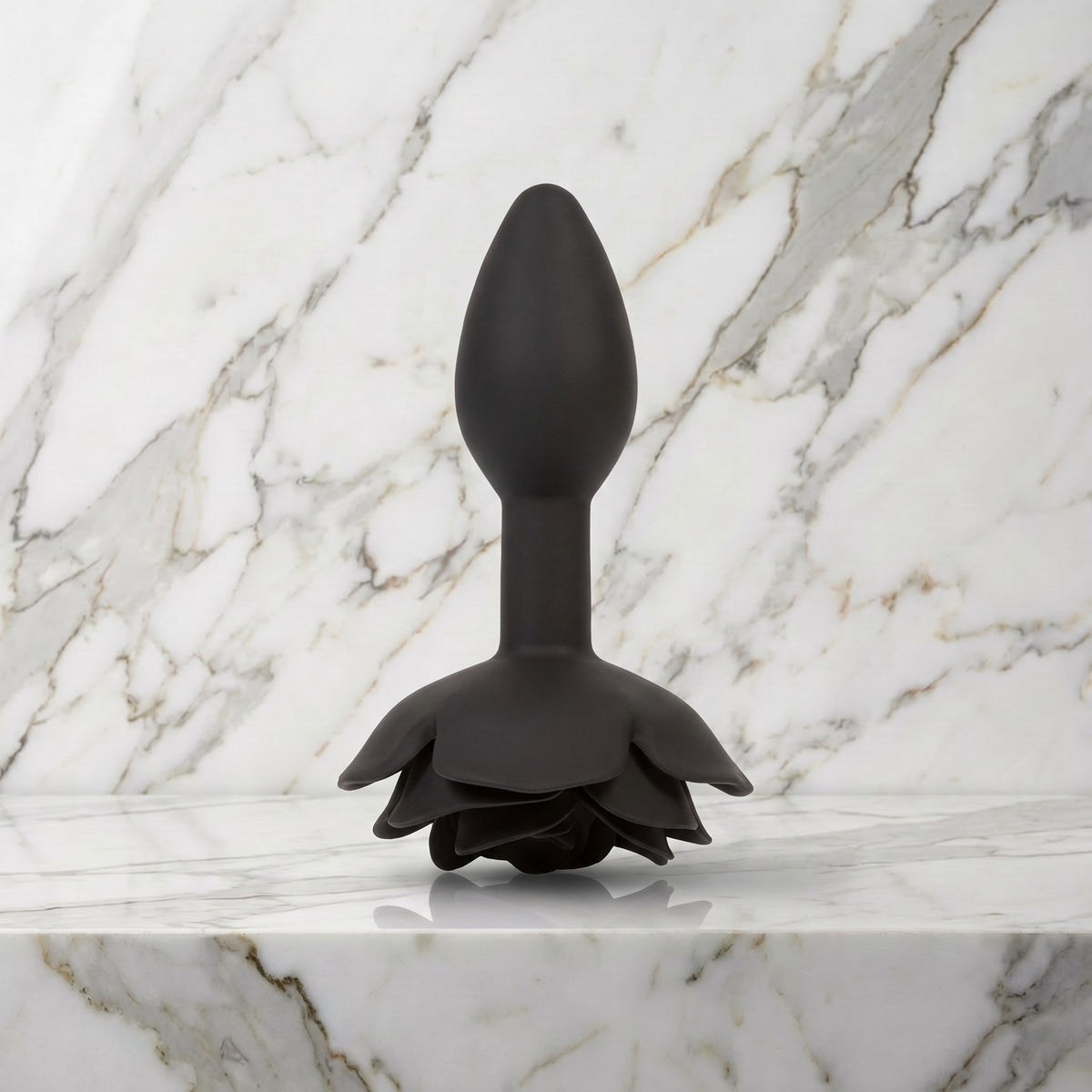 Zwarte buttplug met roos als voet staand op een marmeren plank, Rose buttplug S