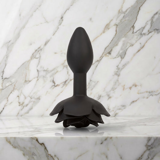 Zwarte buttplug met roos als voet staand op een marmeren plank, Rose buttplug S