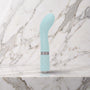 Lichtblauwe Sassy G-spot vibrator met gewatteerd handvat op een marmeren plank