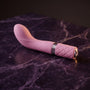 Sfeerbeeld: lichtroze Sassy G-spot vibrator liggend op donkerpaars marmer