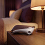 Sfeerbeeld: Satisfyer Pro Traveler op een houten nachtkastje naast een warme lamp