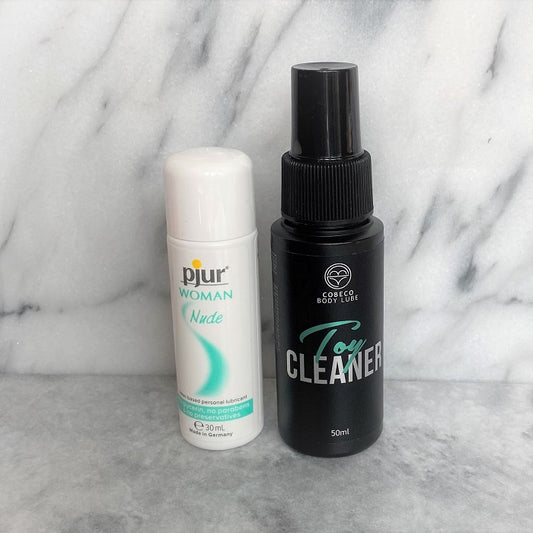 Pjur Woman Nude glijmiddel en Cobeco Toy Cleaner setje op marmeren achtergrond