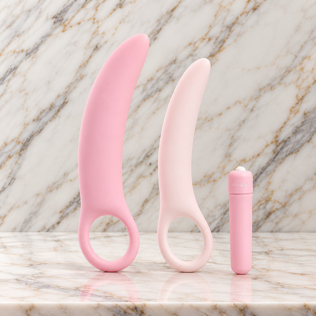 Dilatorset met vibraties op marmer: twee roze siliconen dilators met vingerlus en de bulletvibrator