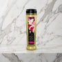 Fles Shunga Amour massageolie van 240 ml met Japanse prent op een marmeren plank