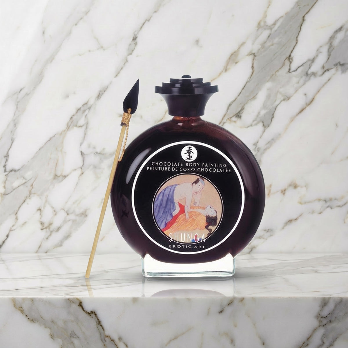Ronde glazen fles chocolade bodypaint met penseeltje op een marmeren plank, Shunga