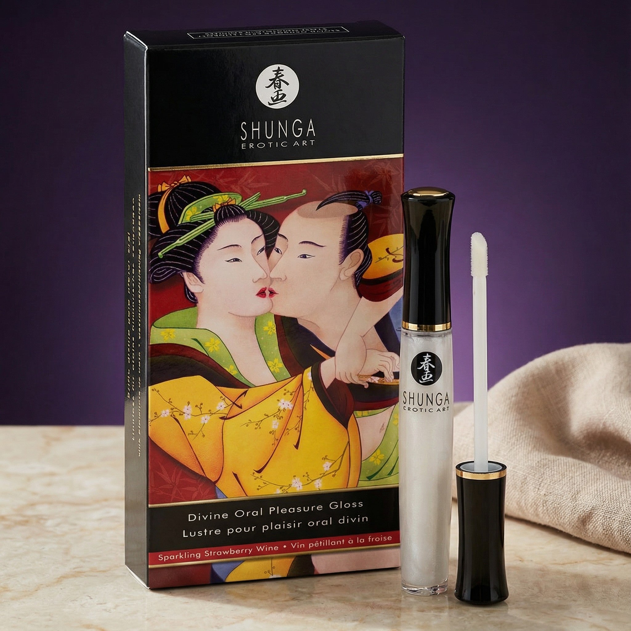 Doos en flesje van de Shunga Divine Aardbeien op een marmeren tafel tegen paars