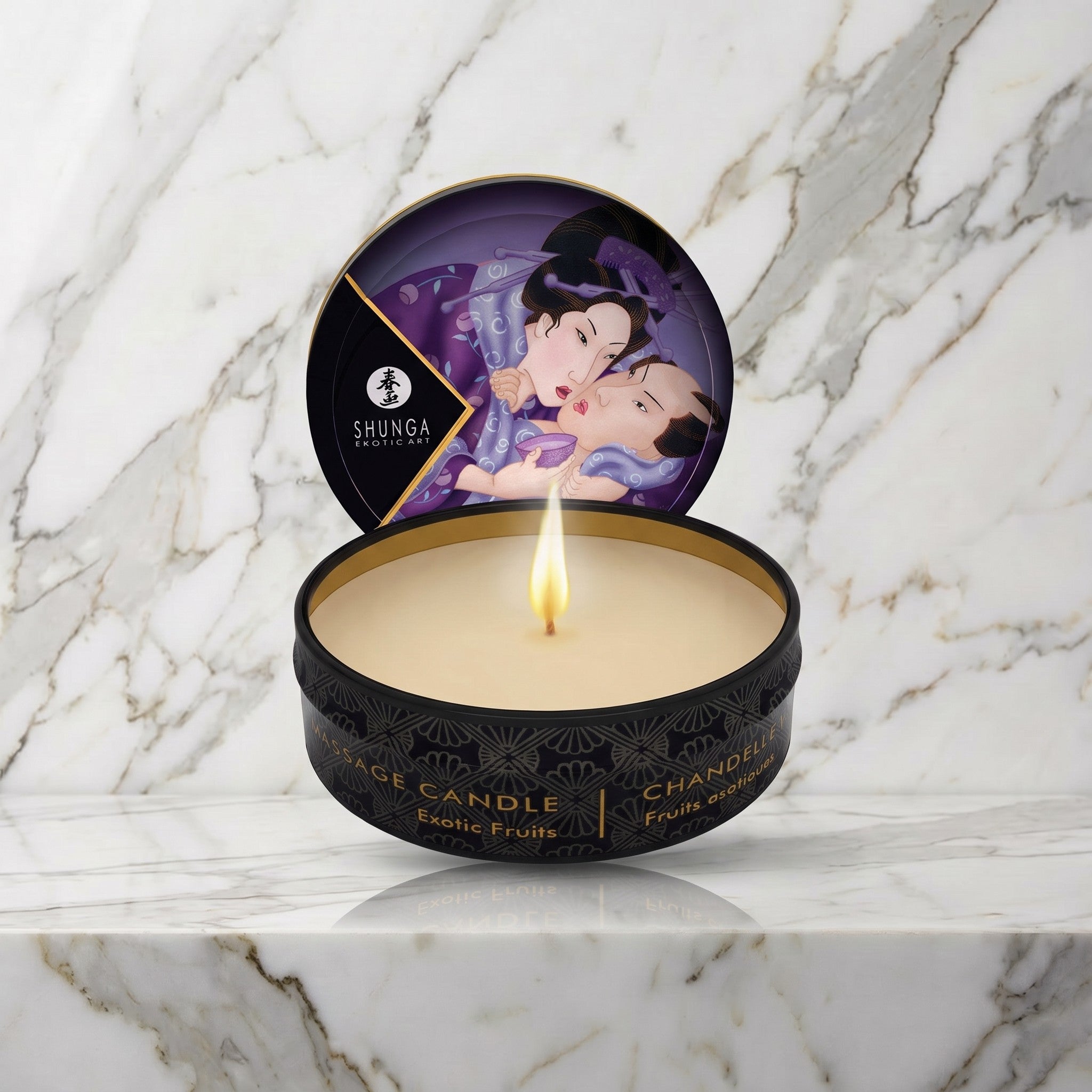 Shunga mini massagekaars Exotic Fruits, open blikje met brandende kaars op een marmeren plank