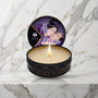 Shunga mini massagekaars Exotic Fruits, open blikje met brandende kaars op een marmeren plank