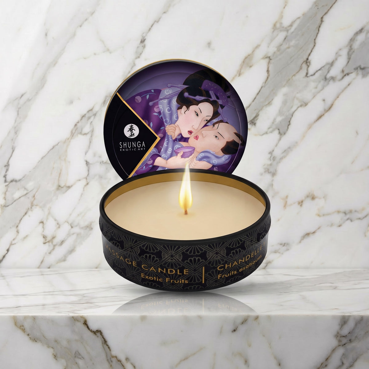 Shunga mini massagekaars Exotic Fruits, open blikje met brandende kaars op een marmeren plank