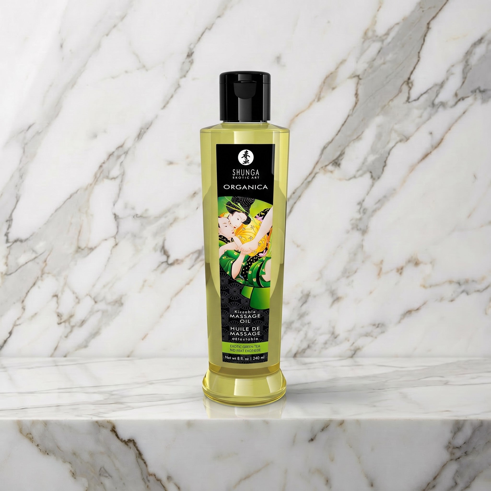 Fles groene thee massageolie met zwart etiket op een marmeren plank, Shunga Organica