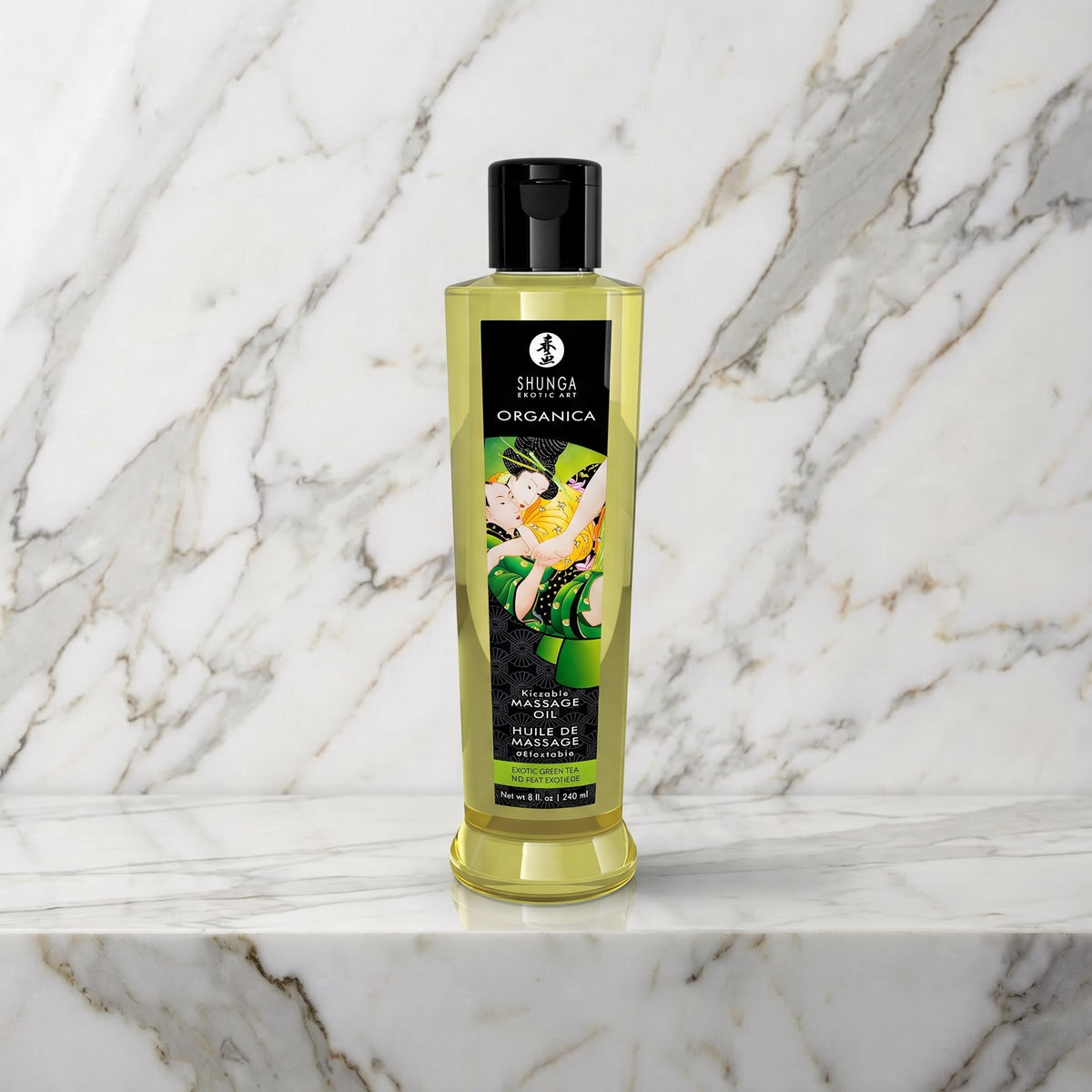 Fles groene thee massageolie met zwart etiket op een marmeren plank, Shunga Organica