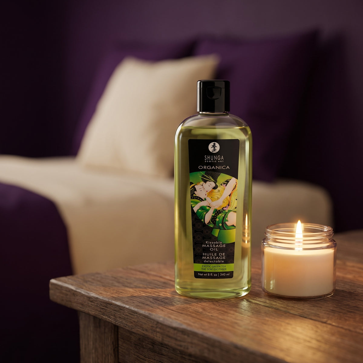 Sfeerbeeld: fles Shunga massageolie op een houten nachtkastje naast een brandende kaars