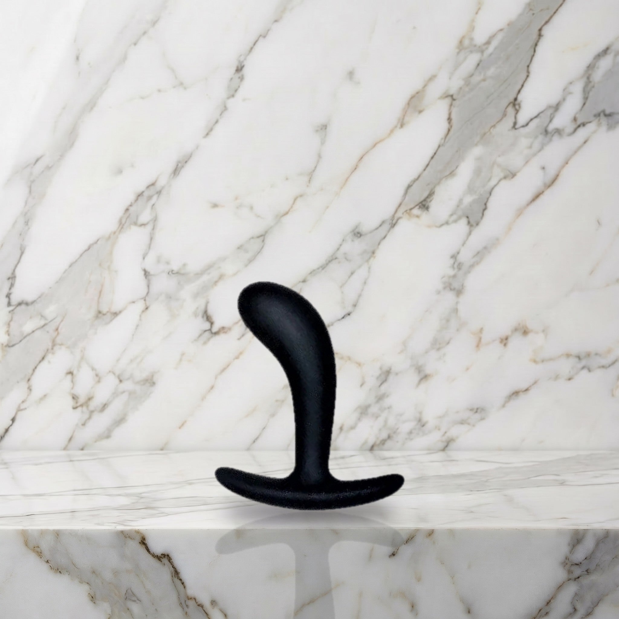 Kleine zwarte gebogen buttplug rechtop op een marmeren plank, Star Yed 1