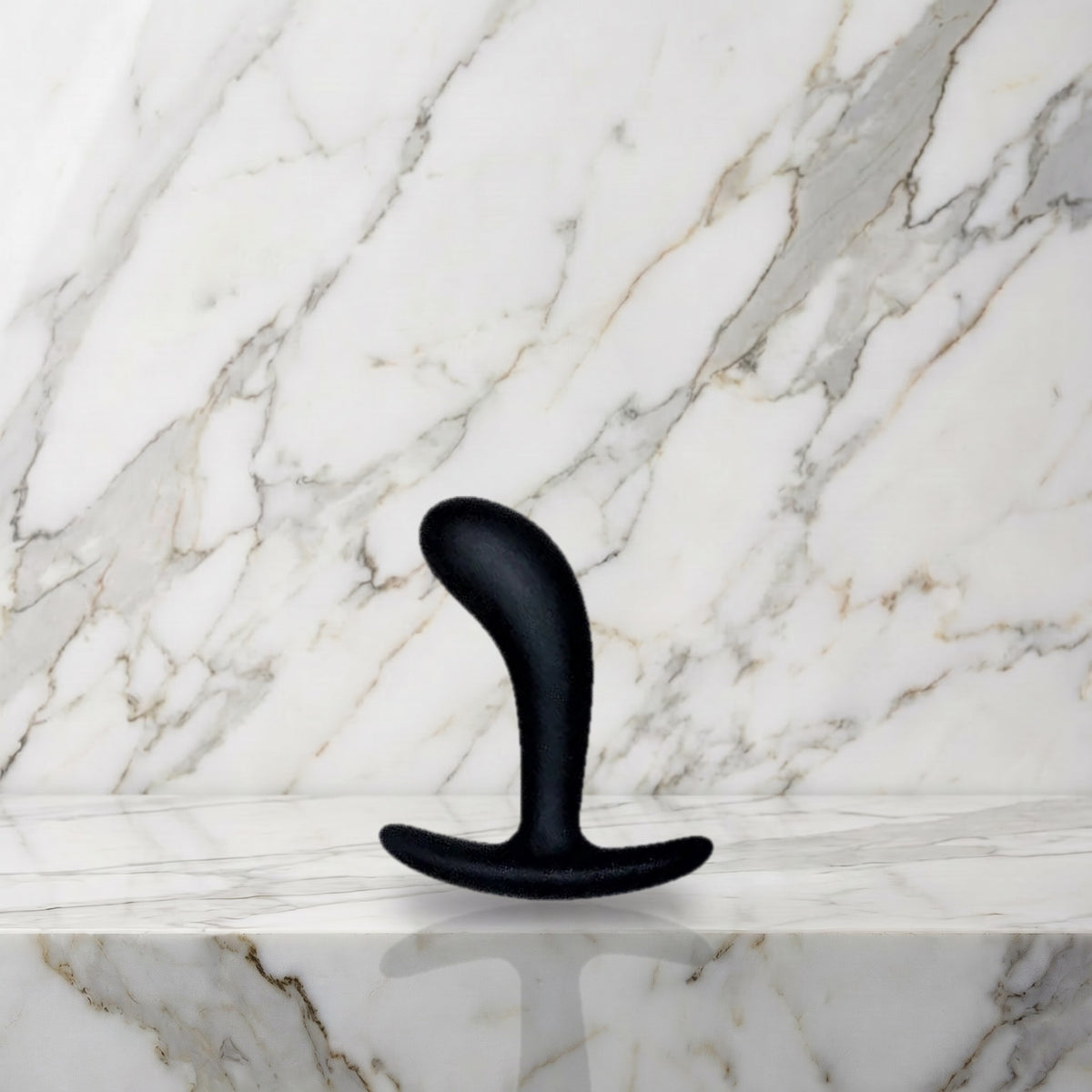 Kleine zwarte gebogen buttplug rechtop op een marmeren plank, Star Yed 1