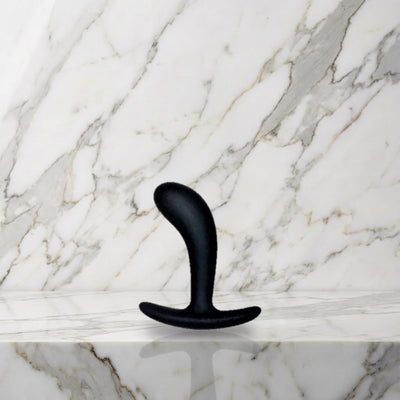 Kleine zwarte gebogen buttplug rechtop op een marmeren plank, Star Yed 1