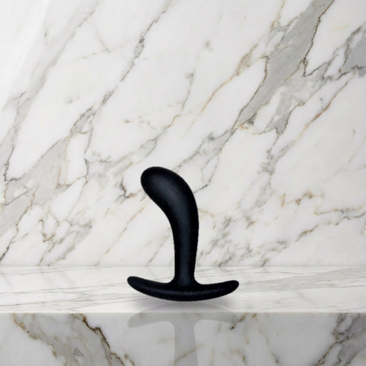 Kleine zwarte gebogen buttplug rechtop op een marmeren plank, Star Yed 1