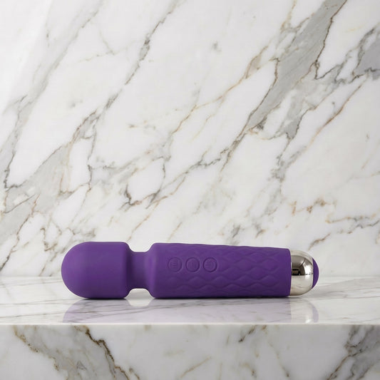 Paarse Super Wand wandmassager klein formaat liggend op een lichte marmeren plank