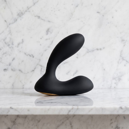 Zwarte gebogen prostaatvibrator met brede voet op een marmeren plank, Svakom Vick Neo