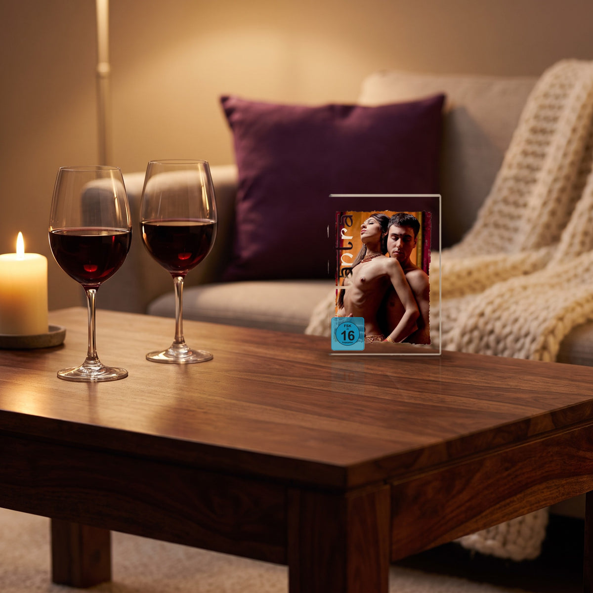 Sfeerbeeld: de Tantra dvd op een salontafel naast twee glazen wijn en een kaars