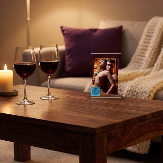 Sfeerbeeld: de Tantra dvd op een salontafel naast twee glazen wijn en een kaars