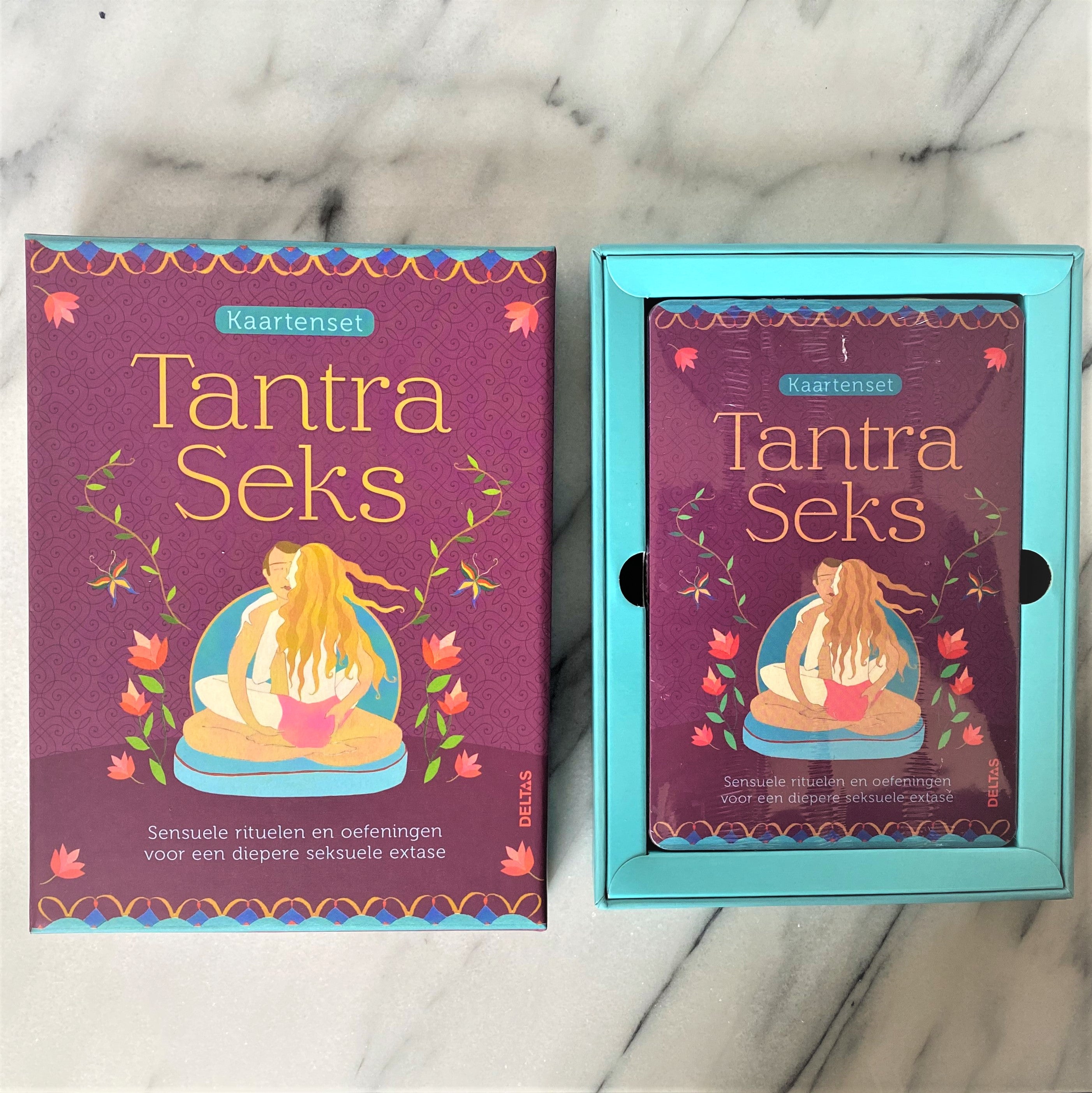 Paars doosje naast de geopende turquoise binnendoos met de kaarten van de Tantra Seks kaartenset