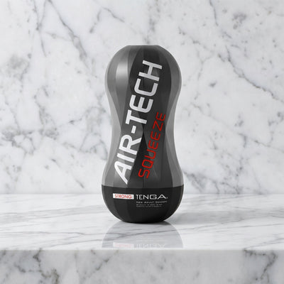 Zwarte zandlopervormige cup op een marmeren plank: Air Tech Squeeze Strong van Tenga