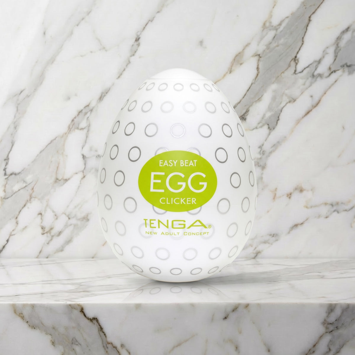 Wit ei met grijze cirkeltjes en groen label op een marmeren plank, Tenga Egg Clicker