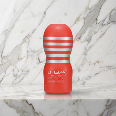 Rode Tenga Original Vacuum Cup rechtop op een marmeren plank