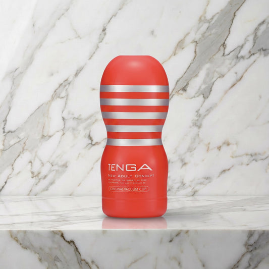 Rode Tenga Original Vacuum Cup rechtop op een marmeren plank