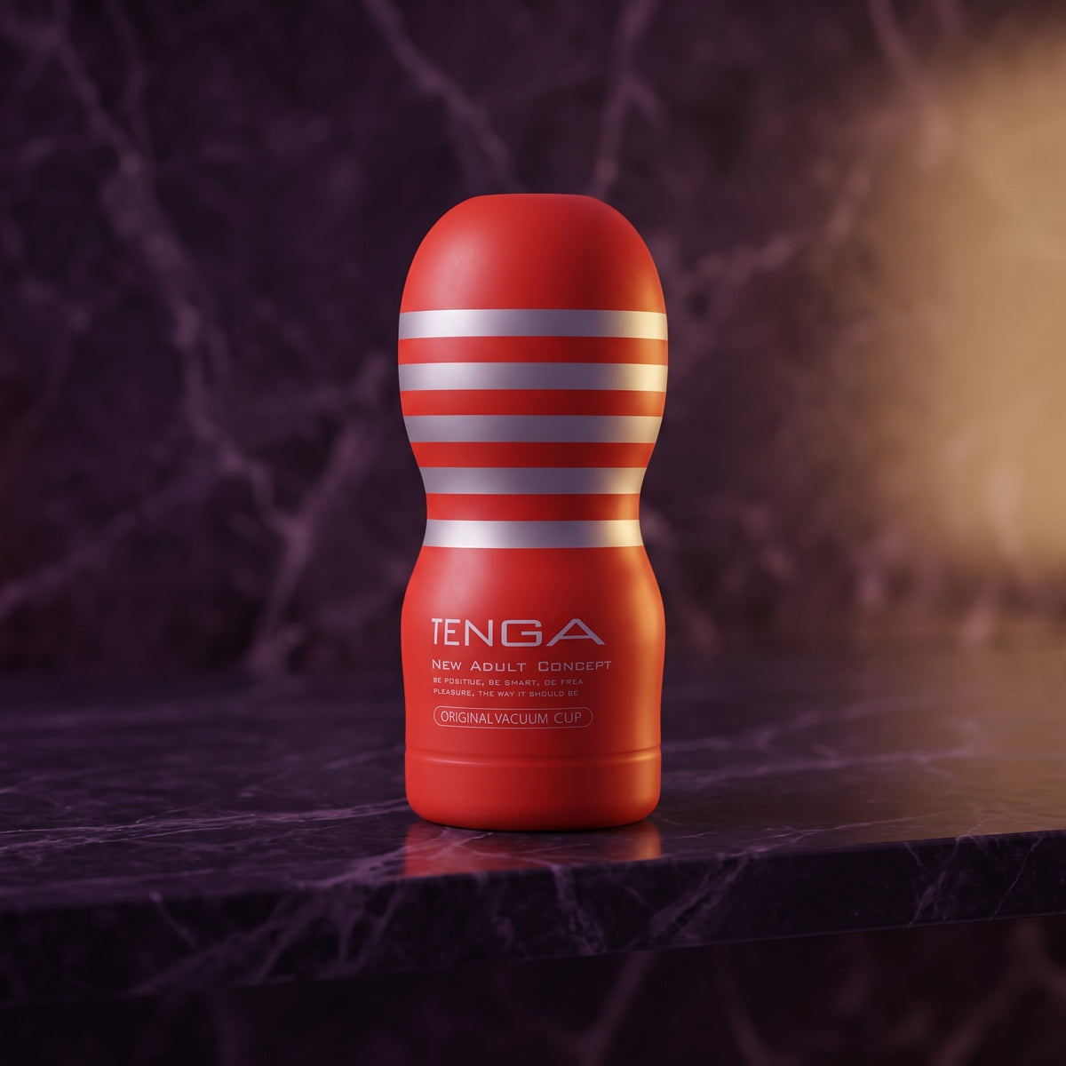 Sfeerbeeld: rode Tenga Original Vacuum Cup op donkerpaars marmer in gedempt licht