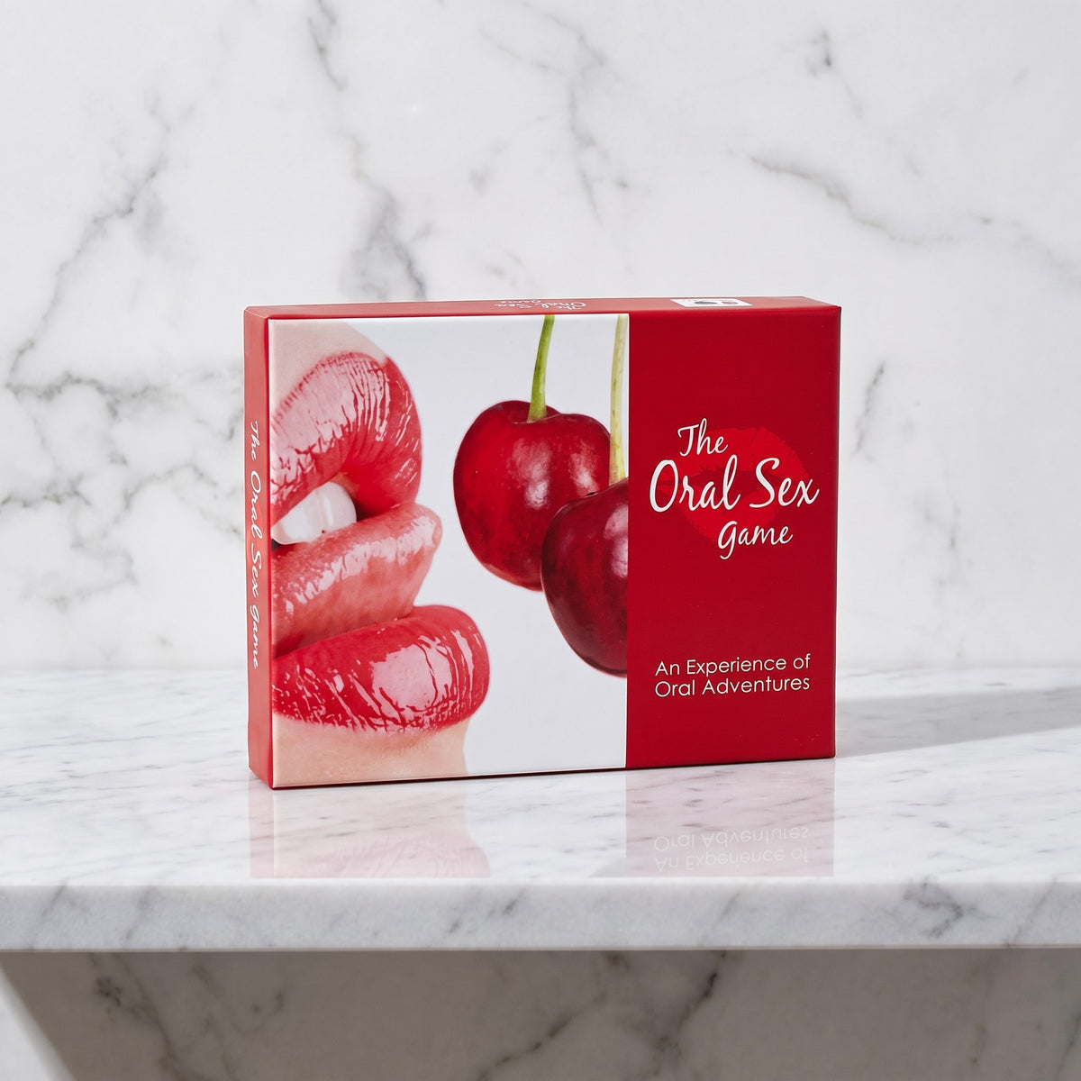 Doos van het erotische bordspel The Oral Sex Game op een marmeren plank