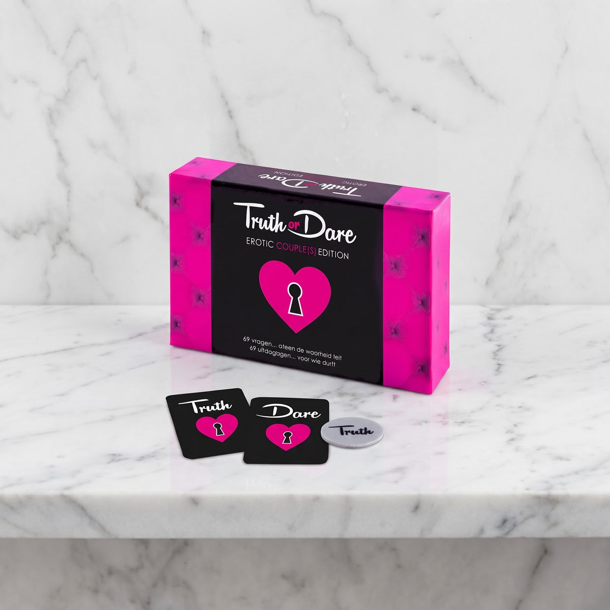 Doos van het kaartspel Truth or Dare Erotic Couple(s) Edition met twee kaarten en munt op marmer