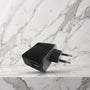Zwart USB-oplaadblok met Europese stekker op een marmeren plank