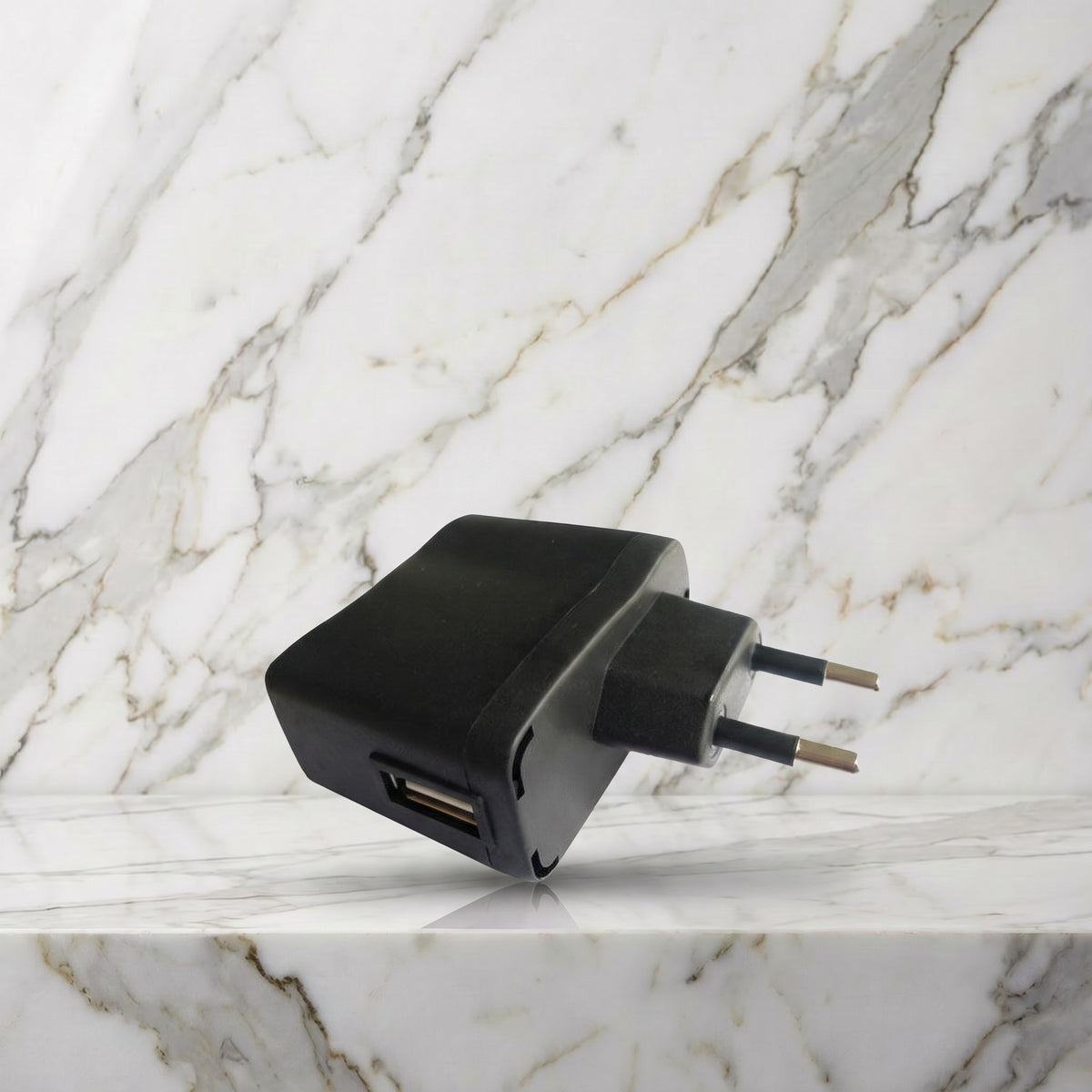 Zwart USB-oplaadblok met Europese stekker op een marmeren plank