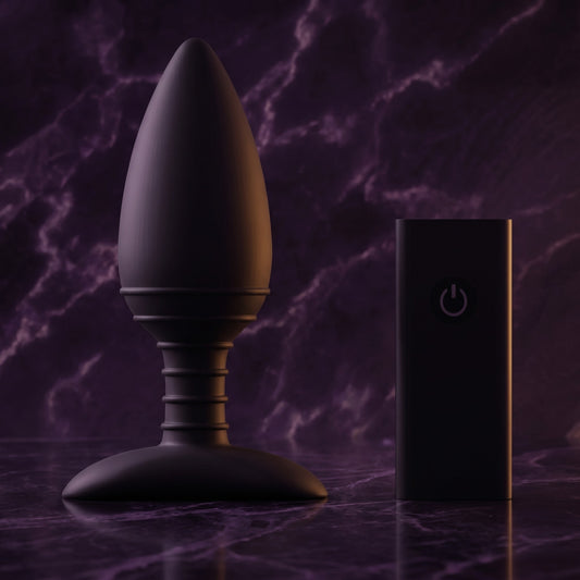 Sfeerbeeld: zwarte vibrerende buttplug met afstandsbediening op donkerpaars marmer