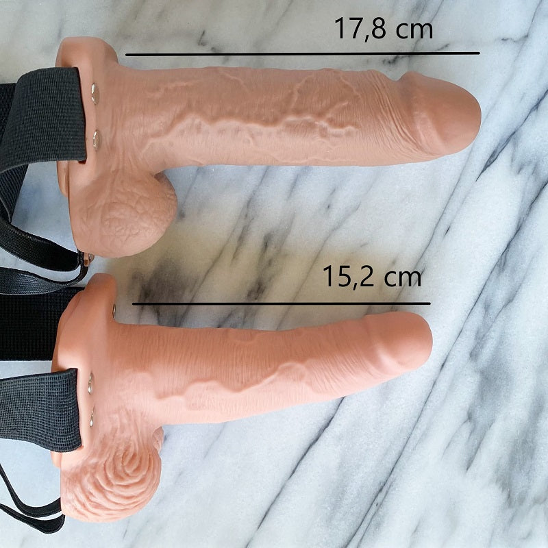 Maat M (17,8 cm) en maat S (15,2 cm) van de holle strap-on naast elkaar op marmer